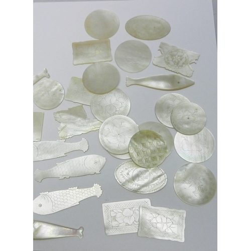 186 - A collection of Chinese mother of pearl gaming counters including fish-shaped and circular examples ... 