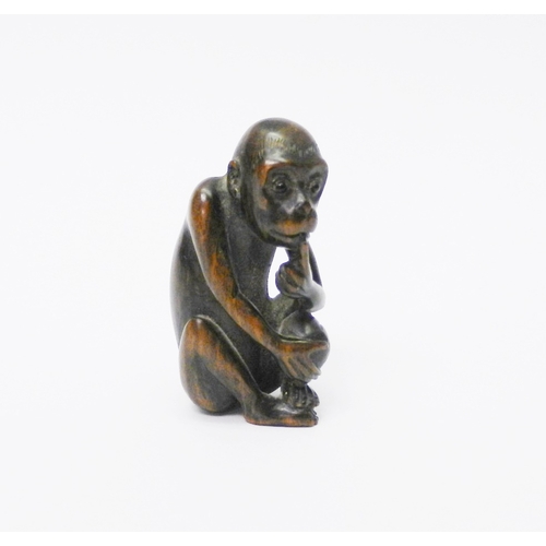 105 - An okimono depicting a seated monkey, carved hardwood, 50mm tall