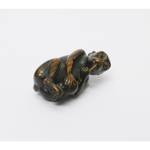 105 - An okimono depicting a seated monkey, carved hardwood, 50mm tall