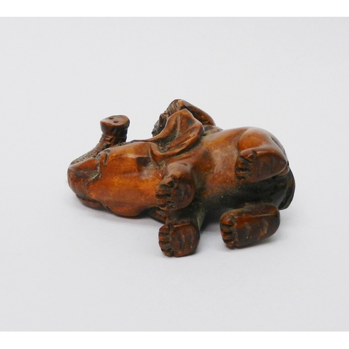 106 - An oriental okimono carved as a monkey sitting on an elephant,  57mm tall.