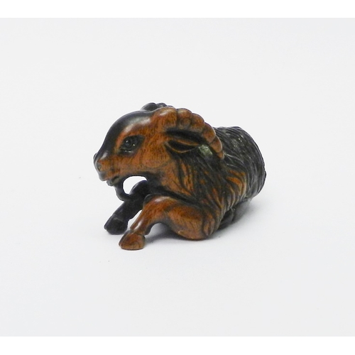 110 - A netsuke depicting a ram, signed to front leg, carved hardwood, 50mm long.