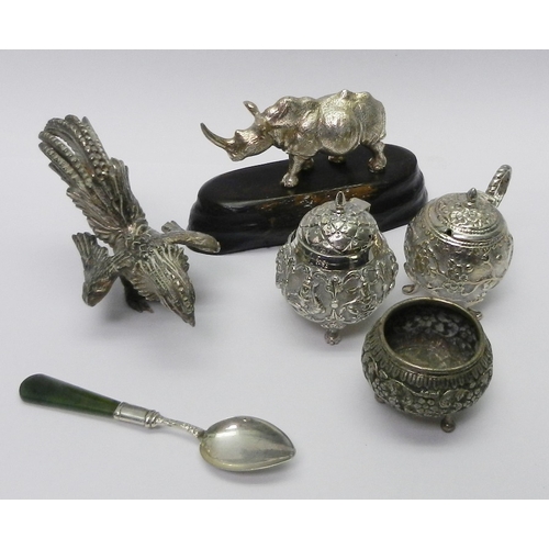 A Patrick Mavros figure of a rhinoceros bearing Zimbabwean marks, white metal on a hardwood base, whole 62mm tall; a silver plated cockerel figure; three oriental white metal condiment pots; etc.