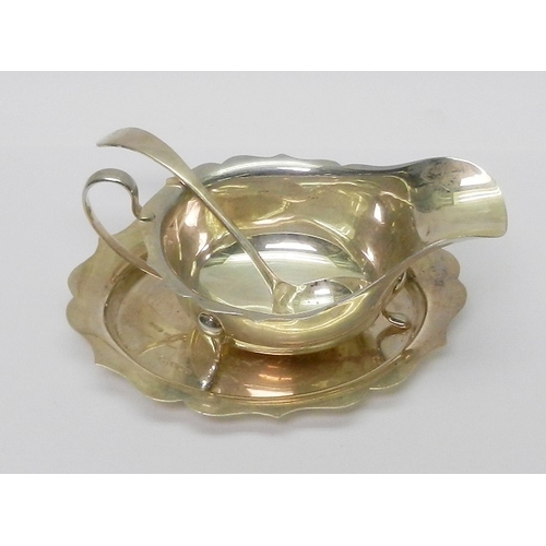 A silver sauce boat together with matching ladle and stand, early 20th cent.  Boat 147mm long / group 250g.