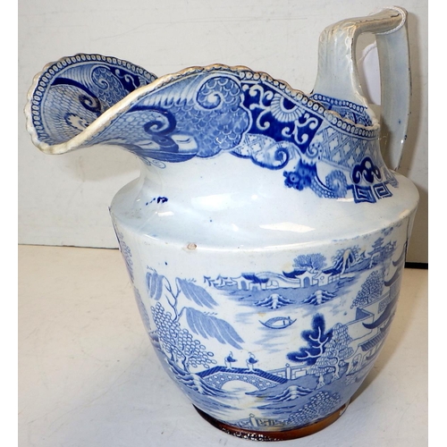 102 - An early 19thC willow pattern jug together with a 19thC hot water pot 22cm tall (2)