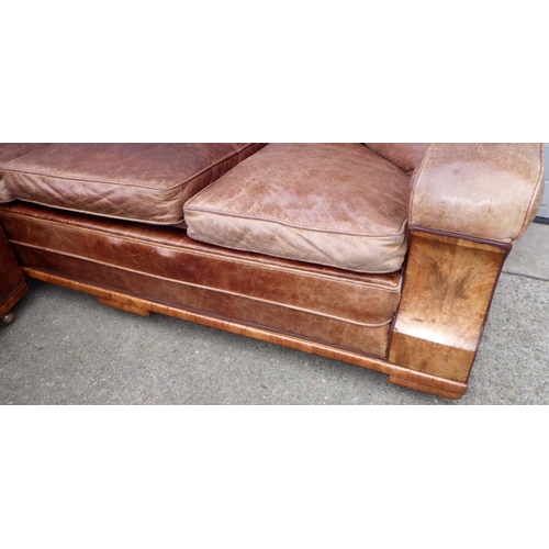 531 - A brown leather upholstered walnut faced three piece suite, settee 190cm wide, springs a/f, leather ... 