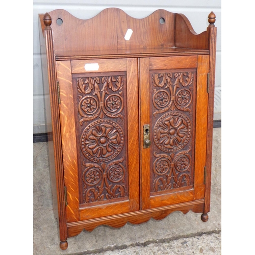 542 - An Edwardian carved oak hanging smokers cabinet, 33cm wide