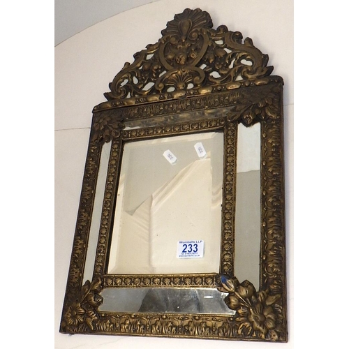 233 - An embossed brass cushion mirror 60 x 33cm