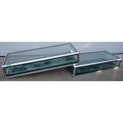 556 - A pair of aluminium framed table top flat cabinets, one missing sliding doors, 138cm long, 57cm deep... 