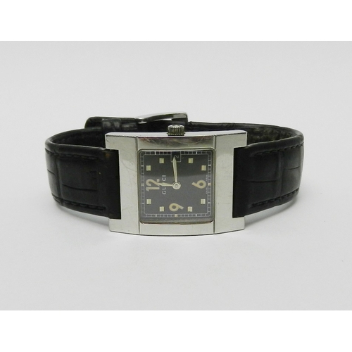 2 - A Gucci 7700L wristwatch comprising a quartz movement in a rectangular steel case on a Gucci leather... 