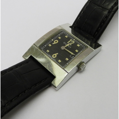 2 - A Gucci 7700L wristwatch comprising a quartz movement in a rectangular steel case on a Gucci leather... 