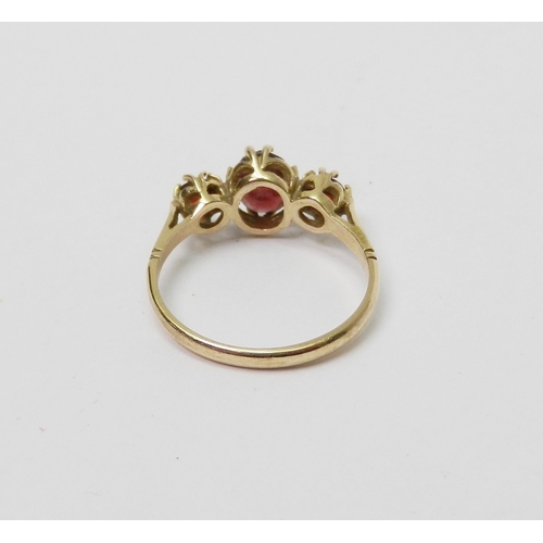 33 - A trilogy ring comprising oval cut garnets in a 9ct gold claw setting, late 20th cent.  1.5g / centr... 