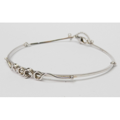 34 - A bangle of part articulated design having a central applied twist / loop motif, platinum bearing Sh... 