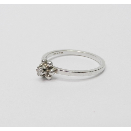 35 - A solitaire ring, platinum set with a single round cut diamond in a raised claw setting above a six ... 