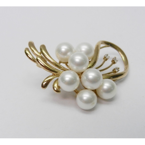 39 - A brooch of spray design, yellow metal marked 9K set with three round cut diamonds and seven pearls.... 