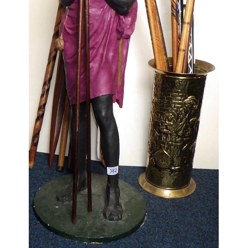 382 - A 95cm tall Masai Warrior figure together with carved walking sticks and stick stand (qty)