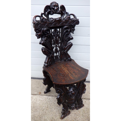 455 - A figural carved hall chair, crest repaired