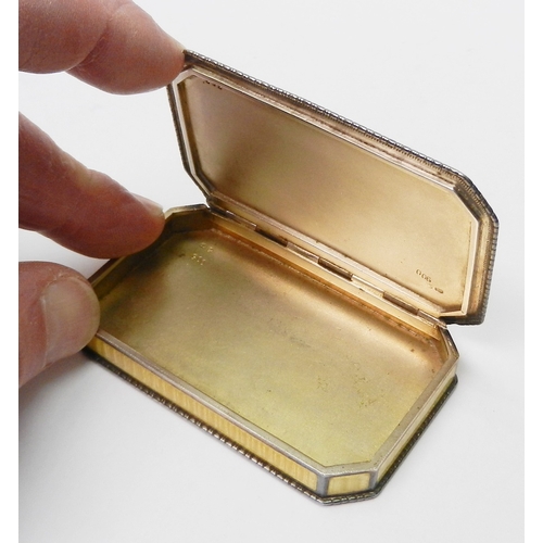 27 - An Austrian snuff box having a sprung hinge lid, white metal marked 900 and enamel on engine-turned ... 