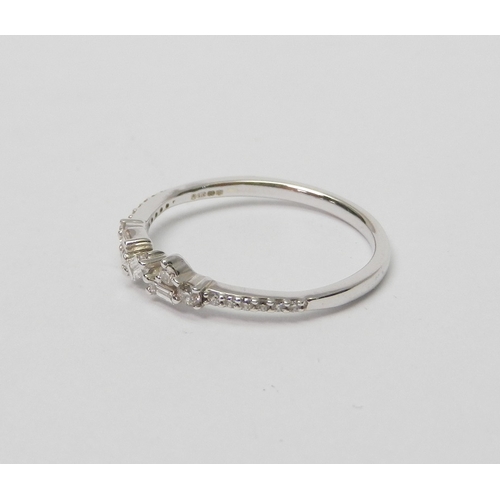 74 - A 9ct white gold and diamond half-hoop ring comprising a central setting of three baguette cut stone... 