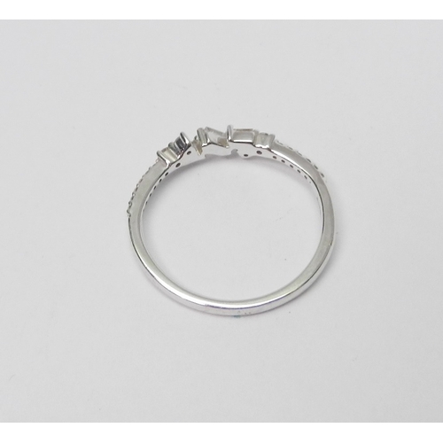 74 - A 9ct white gold and diamond half-hoop ring comprising a central setting of three baguette cut stone... 