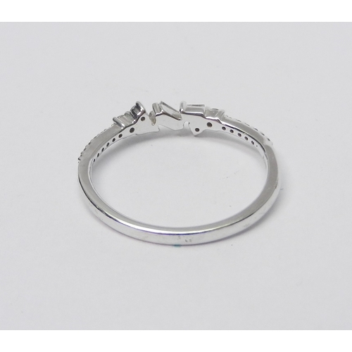 74 - A 9ct white gold and diamond half-hoop ring comprising a central setting of three baguette cut stone... 