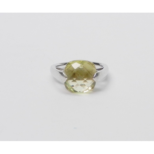 A modern Art Jewellery single stone statement ring, 9ct white gold set with a cushion shaped green citrine, marked ATP with London assay mark, no date.  4g gross / stone 10mm across claws.