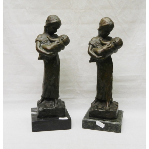 124 - Two matching figurines depicting a female figure holding a child, bronze on stone base, modern.  Eac... 