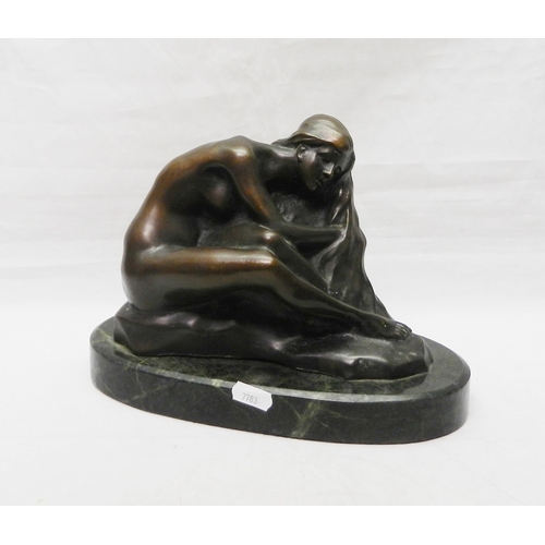 138 - A figurine depicting a seated female nude, bronze on a stone base, modern.  Base 265mm long.