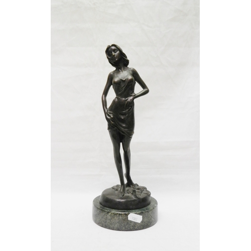 139 - A figurine depicting a partially clothed woman, bronze on a stone base, modern. 315mm tall