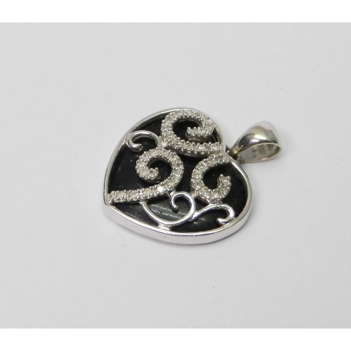 75 - A heart-shaped pendant, 9ct white gold set with diamonds over an onyx core.  3g gross / 23mm long in... 