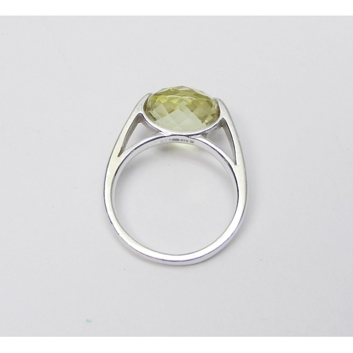 76 - A modern Art Jewellery single stone statement ring, 9ct white gold set with a cushion shaped green c... 