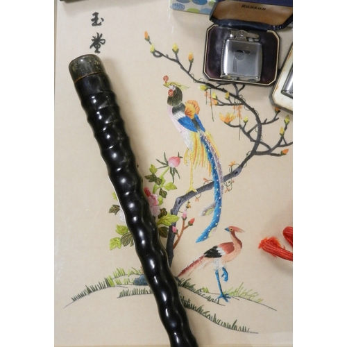 136 - Various cigarette lighters, an ibex horn walking cane, a framed silk work picture.