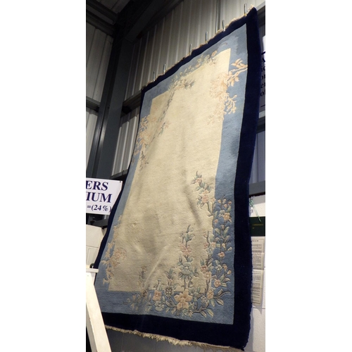 574 - A cream / blue ground Chinese rug, marks (a/f)