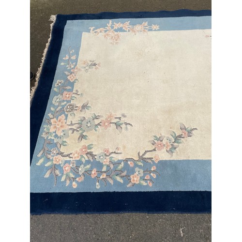 574 - A cream / blue ground Chinese rug, marks (a/f)