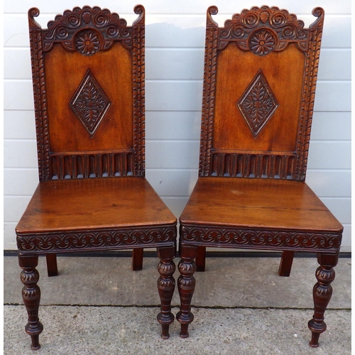 A pair of carved panelled oak hall chairs