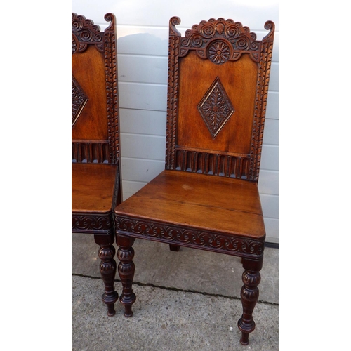 512 - A pair of carved panelled oak hall chairs