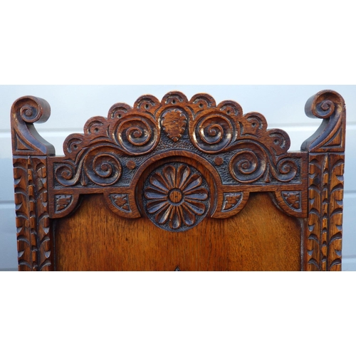 512 - A pair of carved panelled oak hall chairs