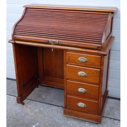 514 - A 1930's oak roll top desk with tambour top and brass handles, 102cm wide