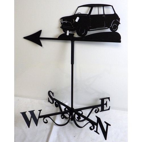 564 - A metal weather vane, surmounted by a Mini car, 68cm tall