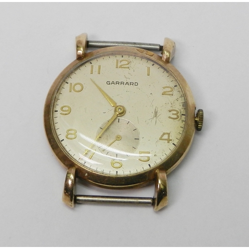 A Garrard wristwatch head comprising an unsigned manual wind 17 jewel lever movement under a champagne dial within a 9ct gold case having flared bombe shaped lugs, c1948.  Case back bearing contemporary presentation inscription, Esso Petroleum Co Ltd interest. With original Garrard presentation box and slip giving more details about the original recipient.