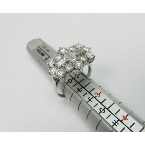 An 18ct white gold and diamond cluster ring comprising three baguette diamonds surrounded by twelve round cut  diamonds.  Largest baguette approx 6 x 3mm / round stones each approx 3.5mm