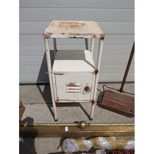 676 - A metal cupboard, push hoover, curtain rail and brass fire curb