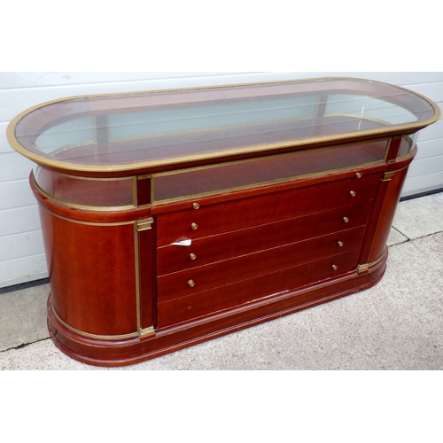 A brass framed flat shop cabinet, 175cm long, scratches to top