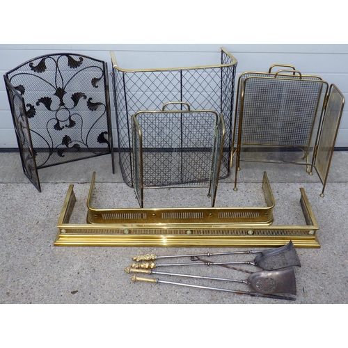 Two brass fenders, five fire guards, two pairs of fire irons and a toasting fork