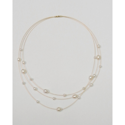 A three strand necklace, yellow metal marked 750 set with pearls, presented in a Bradleys the Jewellers retail box with fabric cover.  Approx 400mm long.