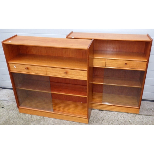 609 - A pair of Nathan teak low bookcases with sliding glass doors, each 102cm wide
