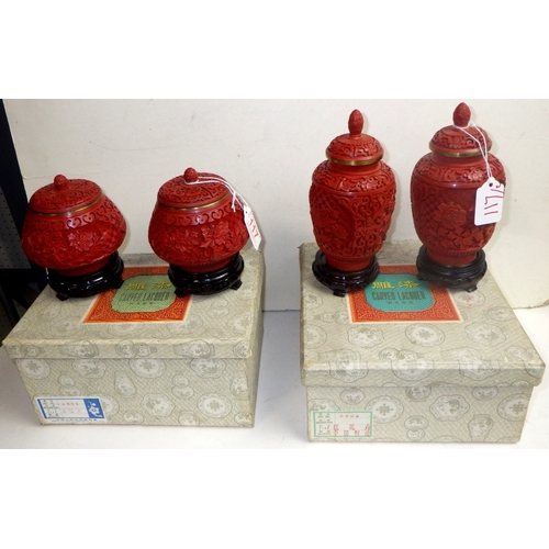 117 - Two pairs of Chinese Red Cinnabar lidded urns / jars with blue enamel interior, 14 & 19cm tall