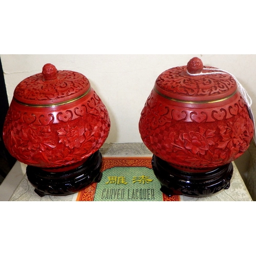 117 - Two pairs of Chinese Red Cinnabar lidded urns / jars with blue enamel interior, 14 & 19cm tall