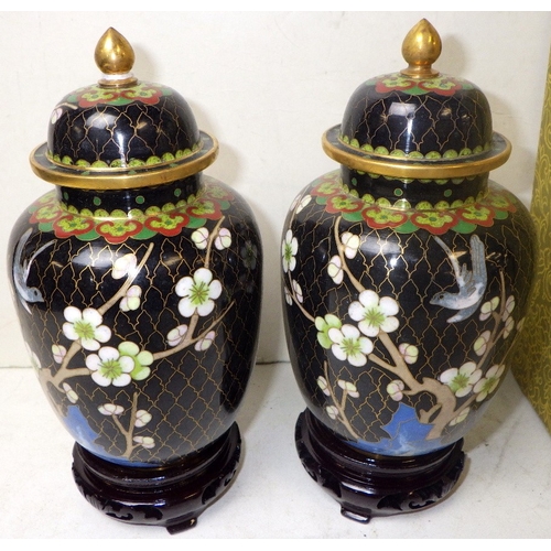 150 - A pair of floral cloisonné lidded urns, 19cm tall