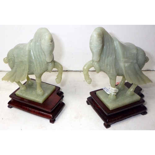 198 - A pair of circa 1960s / 1970s Chinese jade carved warhorses on wooden stands