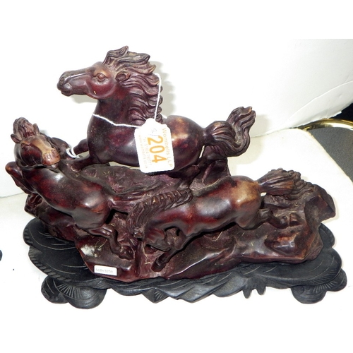 204 - An Oriental carved and polished stone horse sculpture